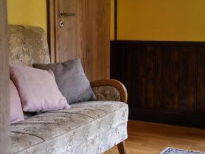 a couch with two pillows on it in a room at Attractive Chalet in Vielsalm with Large Garden in Ennal