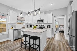 a kitchen with white cabinets and a large island at Central Getaway Off of I-49 in Springdale