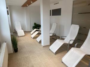 a waiting room with white chairs and a table at FeWo Panoramablick mit Pool und Sauna inklusive in Sankt Englmar