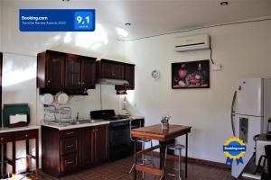 een keuken met houten kasten, een tafel en een koelkast bij Casa Sirena Matanchen in San Blas