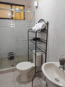 Baño blanco con aseo y lavamanos en Departamento Independiente completo, Centro Histórico Quito, en Quito