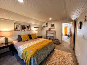 a bedroom with a bed and a table and a desk at Sea Glass Inn in Seaside