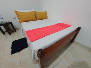 een bed met een rode deken erop in een kamer bij Wilpattu homestay by Ceylon group in Wilpattu