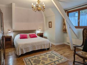 um quarto com uma cama, uma cadeira e um lustre em Gîte Ligny-le-Ribault, 5 pièces, 7 personnes - FR-1-590-391 em Ligny-le-Ribault