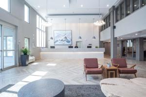 a lobby with two chairs and a reception desk at Sandman Signature Calgary Airport Hotel in Calgary