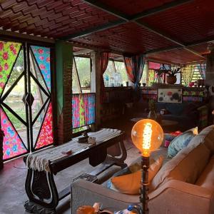 ein Wohnzimmer mit Buntglasfenstern und einem Tisch in der Unterkunft Planta Glamp Farm in Santa María Huatulco