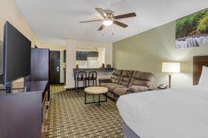 a hotel room with a bed and a living room at Clarion Pointe in Jasper