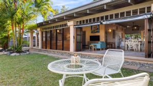 un patio con mesa y sillas frente a una casa en Privacy On Pecten Port Douglas, en Port Douglas