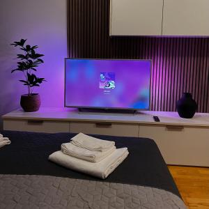 a bedroom with a computer monitor and a bed with towels at Maestral Living Studio Apartment in Zagreb
