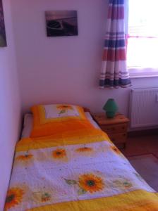 a bedroom with a bed with a flower comforter at Ostseeerlebnis in Graal-Müritz