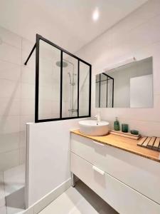 een witte badkamer met een wastafel en een spiegel bij Superb 56 m near Vieux-Port and the Panier in Marseille