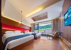 Habitación de hotel con 2 camas y TV de pantalla plana. en 張家界武陵源北岸輕奢客棧 森林公園店, en Zhangjiajie