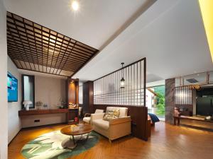 张家界Riverside Peak Lodge Zhangjiajie Wulingyuan National Park的带沙发和桌子的客厅