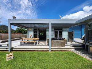 una pérgola con un banco y una mesa en The perfect Hahei bach - Dulop, en Hahei