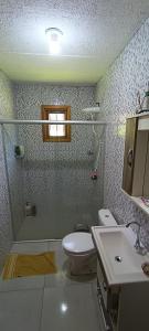 y baño con ducha, aseo y lavamanos. en Casa, en Vespasiano Corrêa