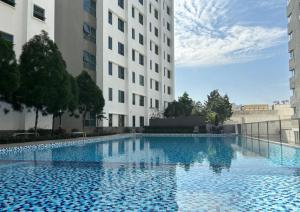 a large swimming pool in front of two buildings at Comfy Park View Stay Above DPulze Mall #DP4 in Cyberjaya