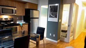 a kitchen with a glass table and a refrigerator at A lovely - 1 bedroom condo with swimming pool in Toronto