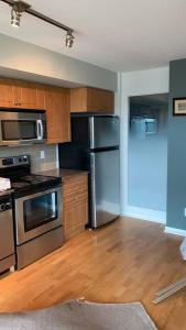 a kitchen with stainless steel appliances and wooden cabinets at A lovely - 1 bedroom condo with swimming pool in Toronto
