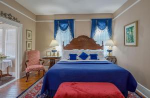 a bedroom with a blue bed and blue curtains at Victorian House Bed and Breakfast in St. Augustine