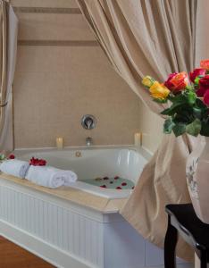 a bath tub with towels and a vase of flowers at Victorian House Bed and Breakfast in Saint Augustine