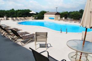 a swimming pool with chairs and a glass table at Clarion Pointe in Jasper