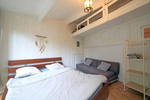 a bedroom with a bed and a couch in it at Chambre 4, calme, 1 station de PARIS in Maisons-Alfort