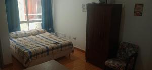 a bedroom with a bed and a dresser and a window at Kitnet Mobiliada no centro de São Leopoldo. in São Leopoldo