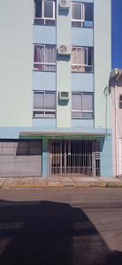 a tall building with a gate in front of it at Kitnet Mobiliada no centro de São Leopoldo. in São Leopoldo