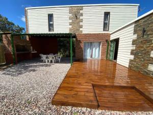 un patio con terrazza in legno di fronte a un edificio di Casa con vista al mar, Punta negra, Maldonado a Punta Ballena