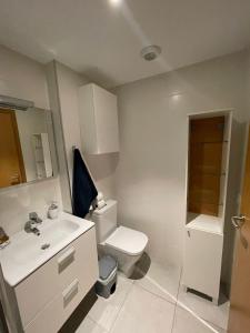 La salle de bains est pourvue de toilettes blanches et d'un lavabo. dans l'établissement El Tesoro, beautiful, two bedrooms tenerife sur, à Adeje