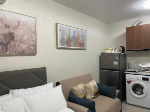 ein Wohnzimmer mit Sofa und Waschmaschine in der Unterkunft CKK Condo Unit in Lapu Lapu City