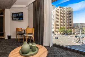 a living room with a table and vases on a table at Song Hotel Sydney in Sydney