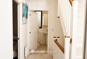 a hallway with a door leading to a bathroom at Modern Beautiful 5 bed -Sleeps 13 - Jacuzzi and Free Parking in Coulsdon