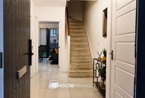 um corredor com uma escada numa casa em Modern Beautiful 5 bed -Sleeps 13 - Jacuzzi and Free Parking em Coulsdon