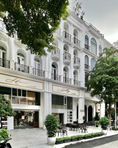 a large white building with tables in front of it at HOME by FLATTO APARTMENT in Ho Chi Minh City