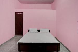 um quarto com uma cama num quarto cor-de-rosa em OYO Hotel star palace em Noida