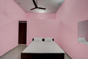różowy pokój z łóżkiem i wentylatorem sufitowym w obiekcie OYO Hotel star palace w mieście Noida