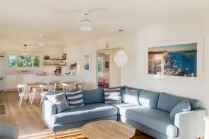 - un salon avec un canapé bleu et une table dans l'établissement Hale Kalani home, à Haena