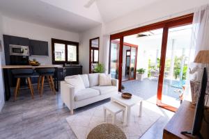 ein Wohnzimmer mit einem weißen Sofa und einer Küche in der Unterkunft Villa Léa 2 bedrooms pool wifi Netflix in Hua Thanon Beach