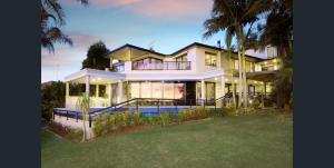 a large white house with a lot of windows at Water Front House in Sydney
