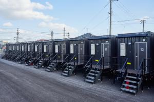 una fila de contenedores negros sentados a un lado de una calle en HOTEL R9 The Yard 長浜 en Nagahama