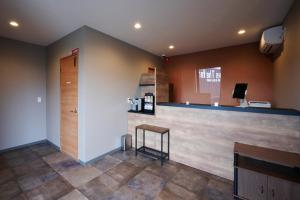 a bar in a salon with a counter and a stool at HOTEL R9 The Yard 長浜 in Nagahama