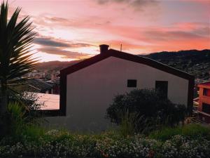 ein weißes Gebäude mit Sonnenuntergang im Hintergrund in der Unterkunft Casa Cielo en Paipa Centro in Paipa