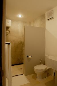 a small bathroom with a toilet and a sink at Uluwatu Stay's Standard Room #1 in Uluwatu