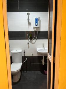 a bathroom with a toilet and a sink at Rahmah Sojourn Center in Johor Bahru