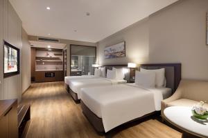 a hotel room with three beds and a couch at Annova Nha Trang Hotel in Nha Trang