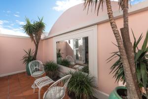 ein Balkon mit weißen Stühlen und Palmen in der Unterkunft Hotel Ravesis in Sydney