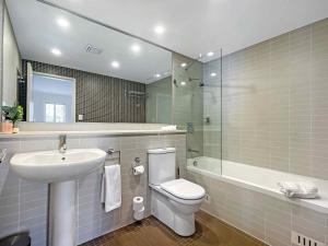 ein Badezimmer mit einem Waschbecken, einem WC und einem Spiegel in der Unterkunft Villa On The Green in Lovedale