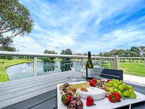 拉夫代爾的住宿－Villa On The Green，一张桌子,上面放着一盘食物和一瓶葡萄酒