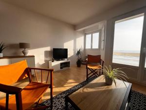 a living room with a table and chairs and a television at Studio spacieux face mer avec balcon et garage, proche plage et commerces aux Sables-d'Olonne - FR-1-197-561 in Les Sables-dʼOlonne